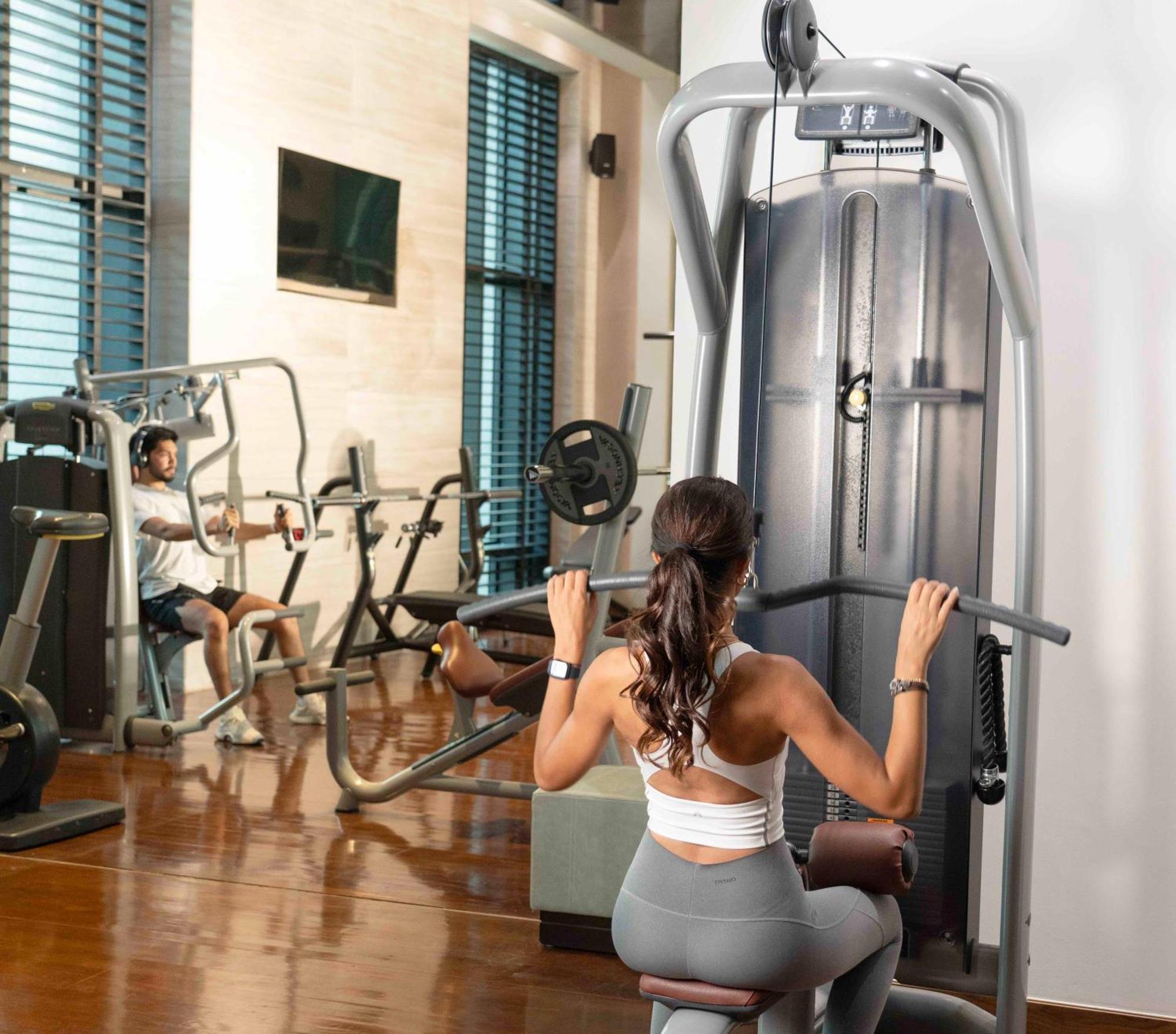 Fairmont Riyadh Eksteriør billede A woman using a lat pulldown machine
